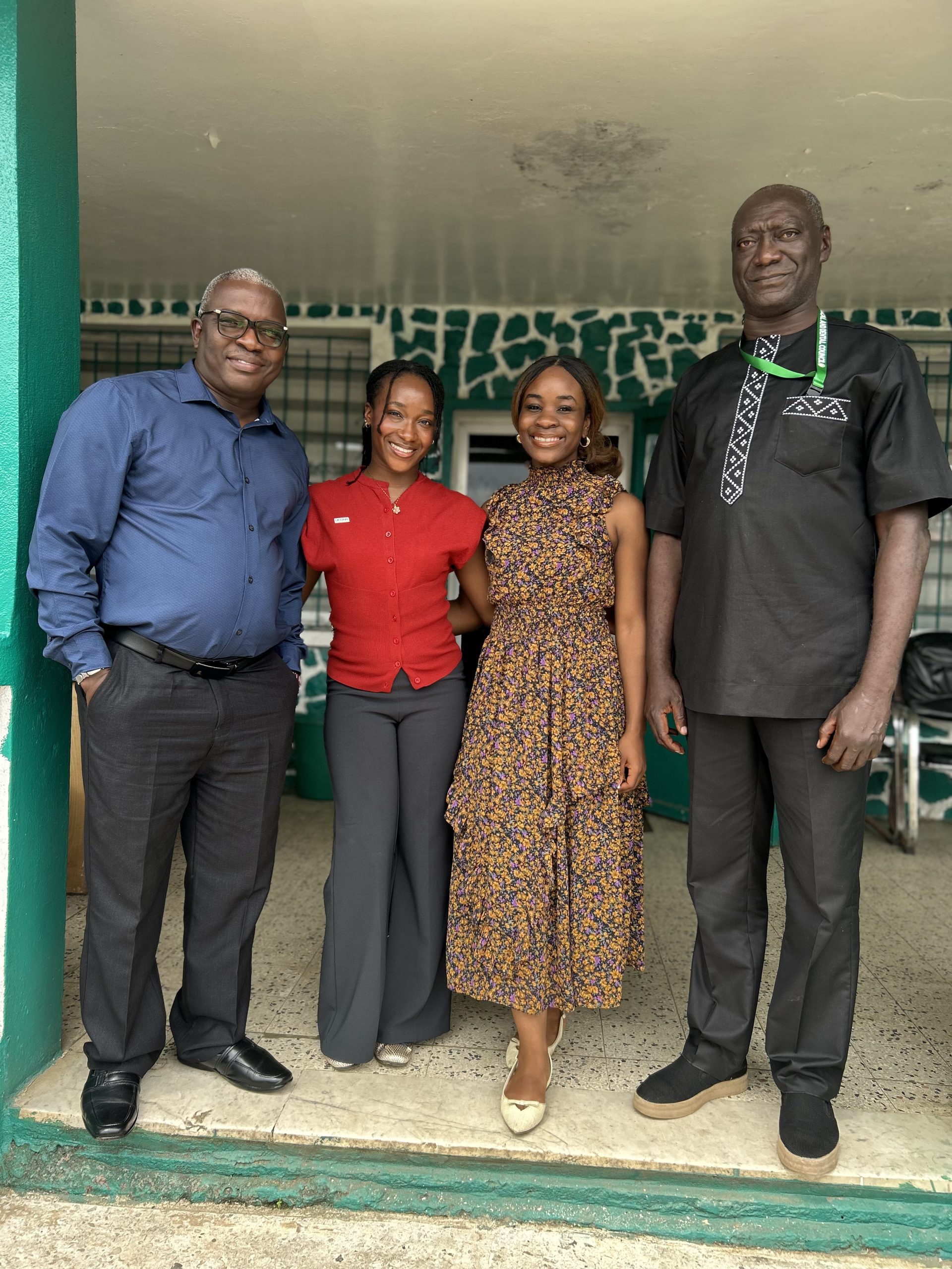 Four people stand together, posing for a group photo. 