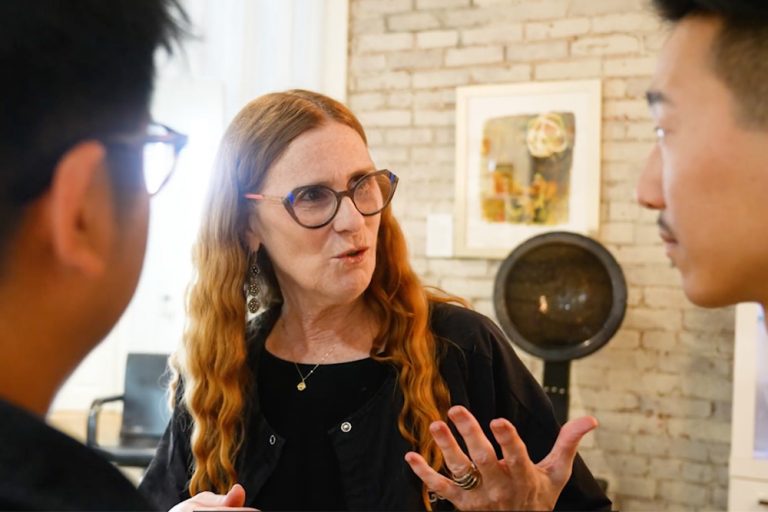 Two men talking to a woman with glasses in salon