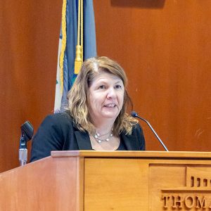 A woman standing behind a podium speaking