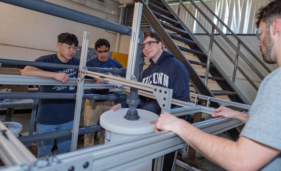 Four male students working on lab equipment.