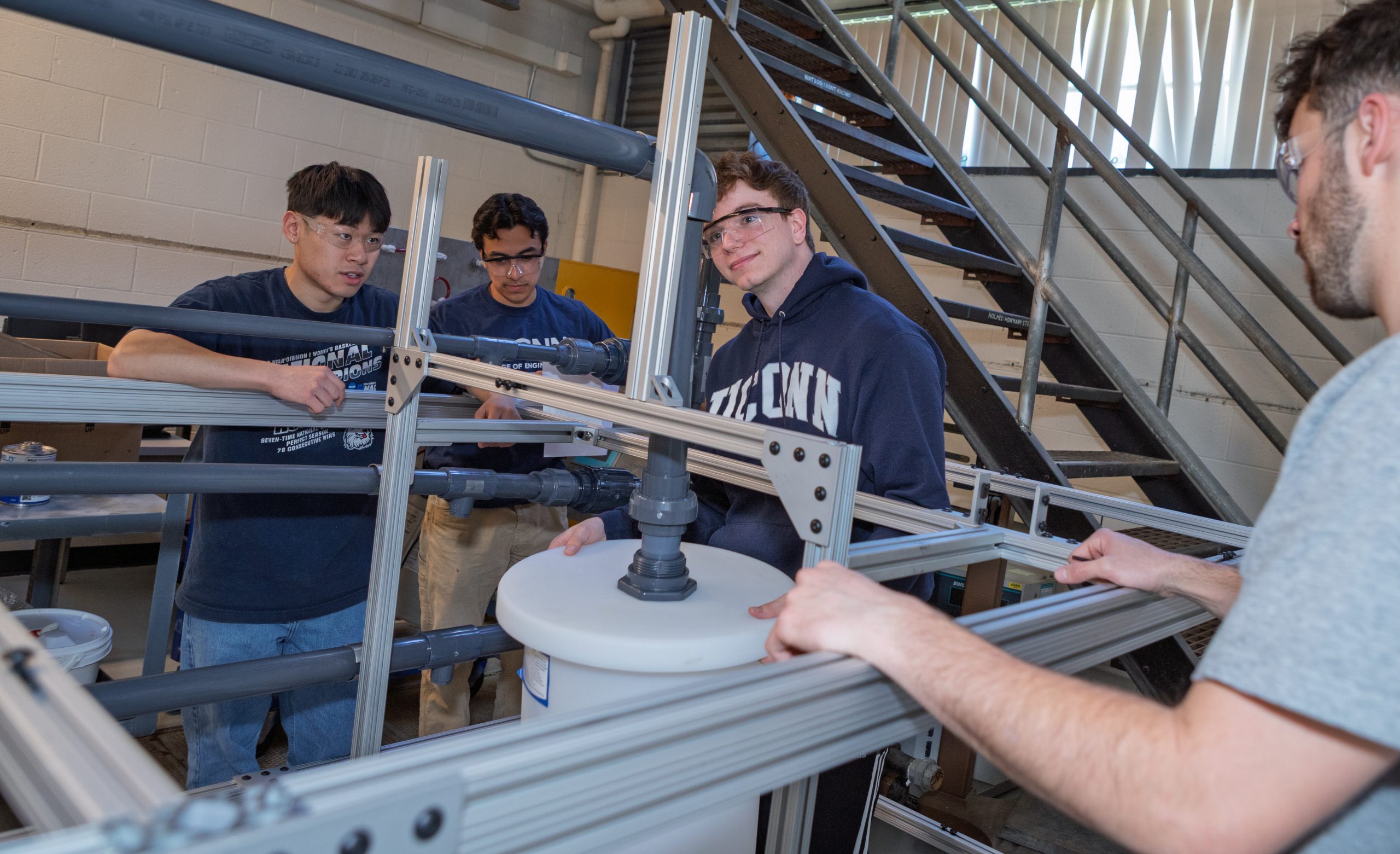 Four male students working on lab equipment.