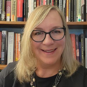 Headshot of a woman with glasses in front of books