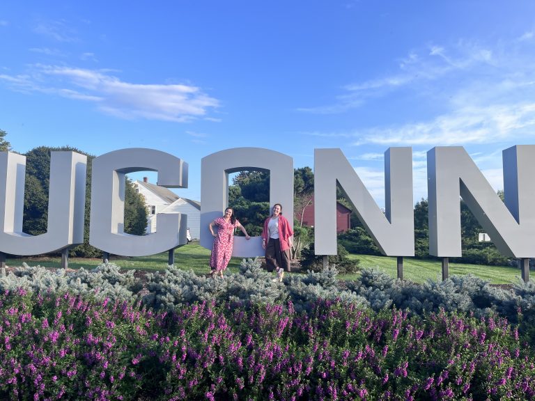 Two DNP students from Chili in front of UConn sign.