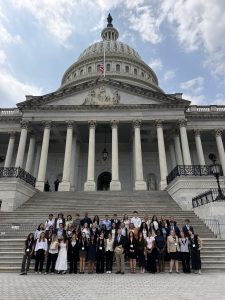 A group of students standing in front of a capitol building