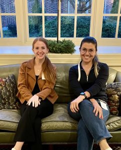 Two women sit cross-legged on a couch