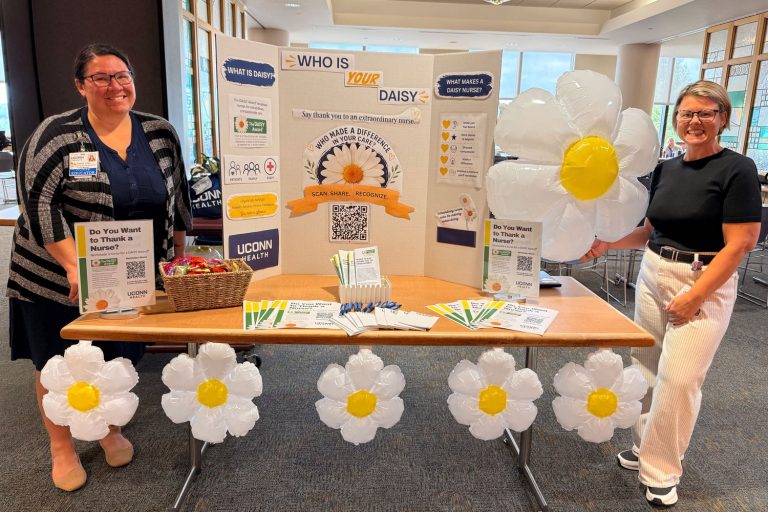 portrait two women at an information table for the DAISY Award for Extraordinary Nurses