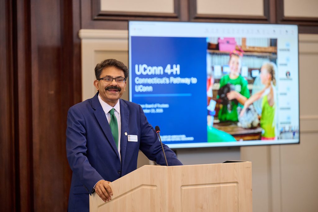 Smiling man stands at podium