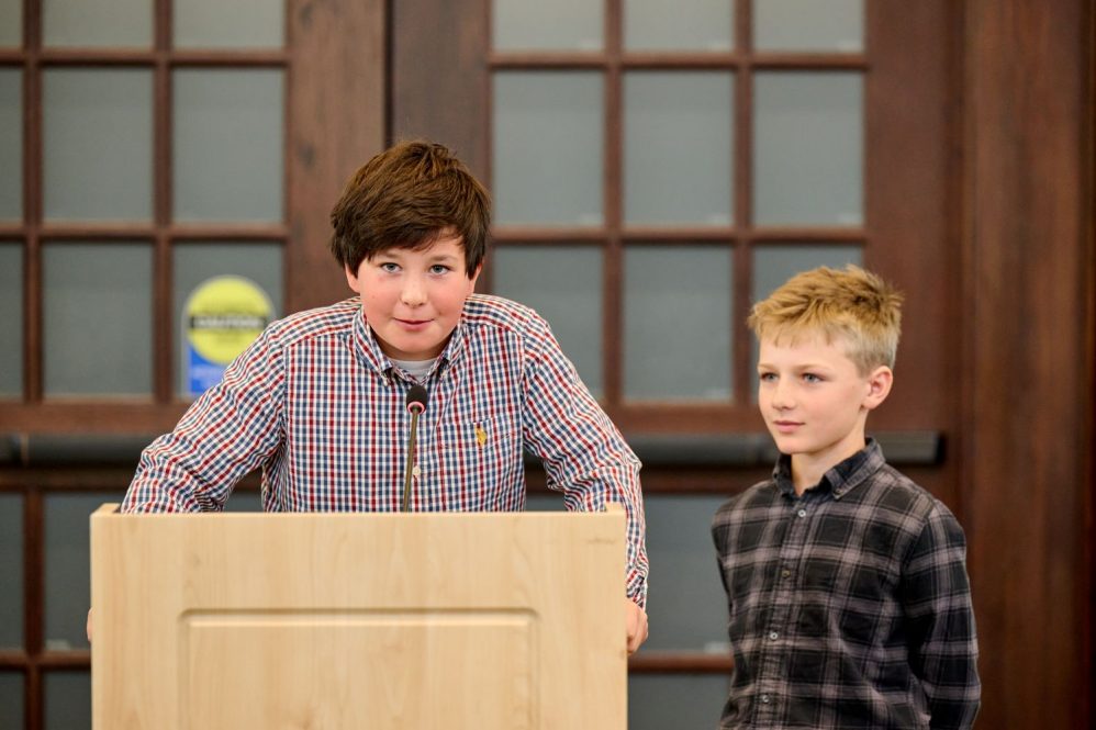 Emmet Salvas, 10, left, and Alex Hermonot, 11 stand at podium