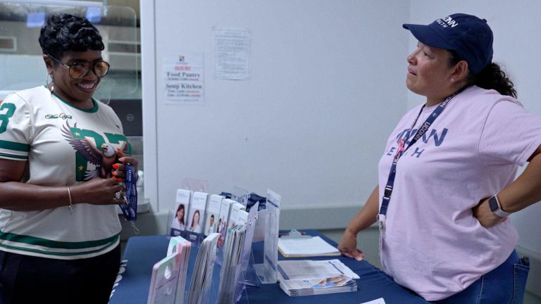 UConn Health Community Health Worker Rosa Agosto discussing early cancer screenings at food pantry in Waterbury. (Ryan Bernat/UConn Health)