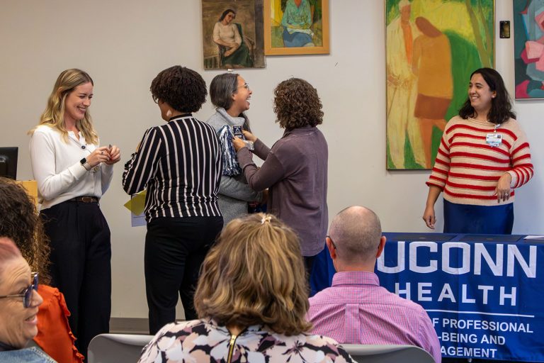 two women pinning two other women at a pinning ceremony