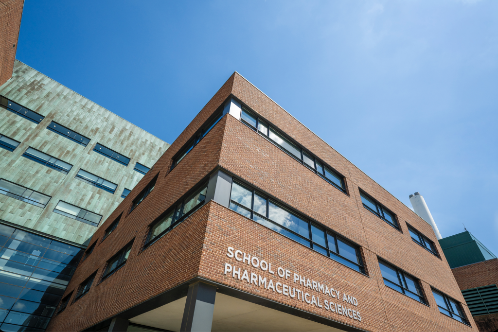 A brick building shot from below. The sign reads School of Pharmacy and Pharmaceutical Sciences.