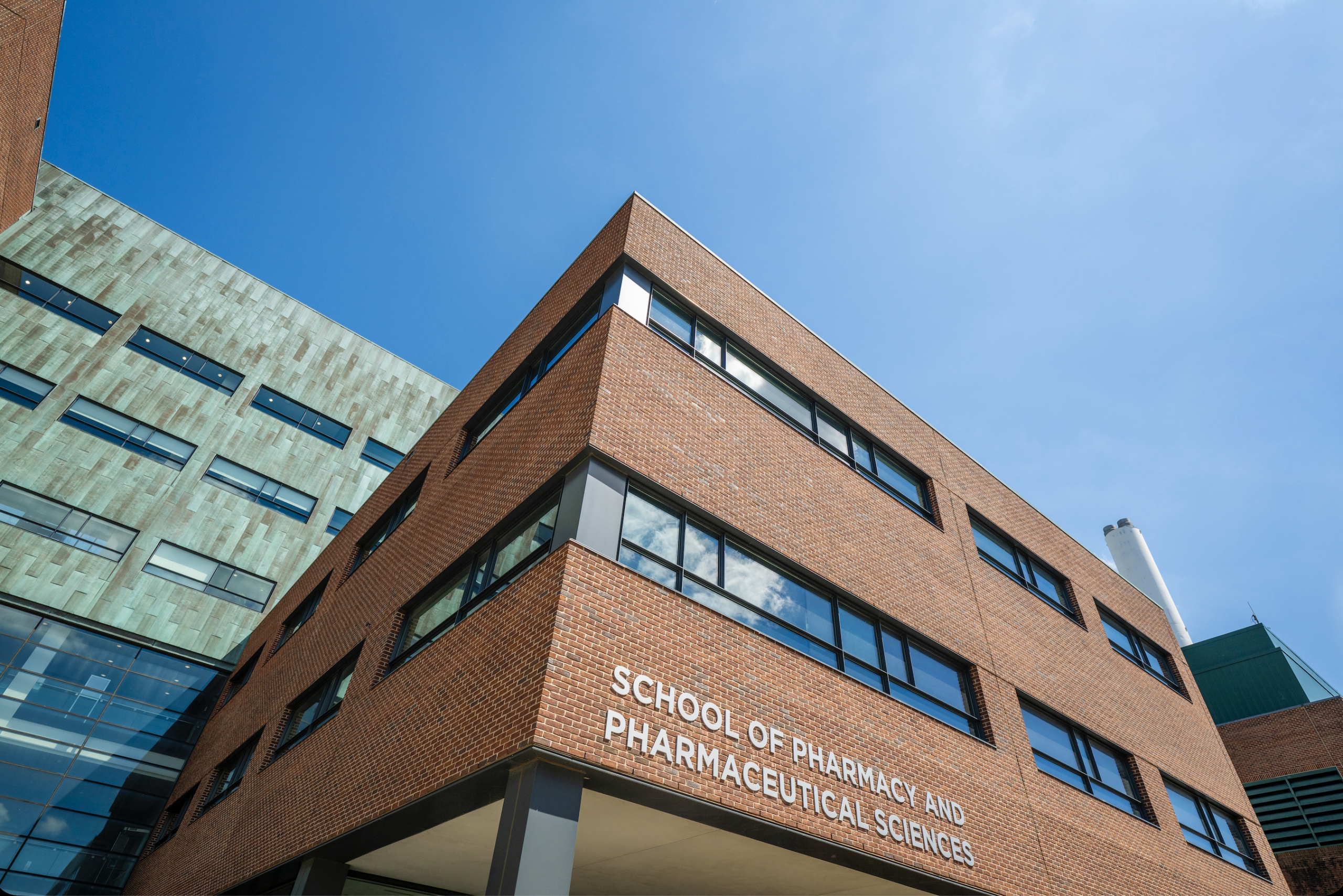 A brick building shot from below. The sign reads School of Pharmacy and Pharmaceutical Sciences.