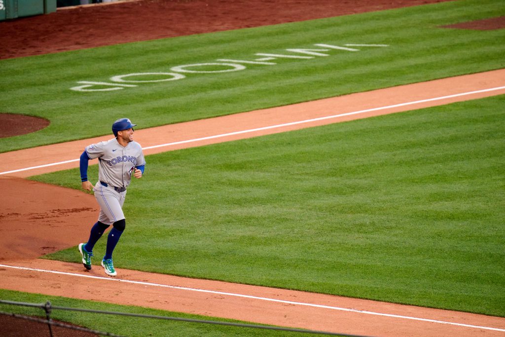A baseball player running the bases after hitting the ball