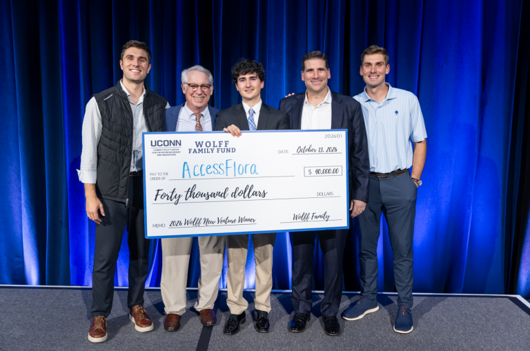 A group of people pose with a large novelty check.