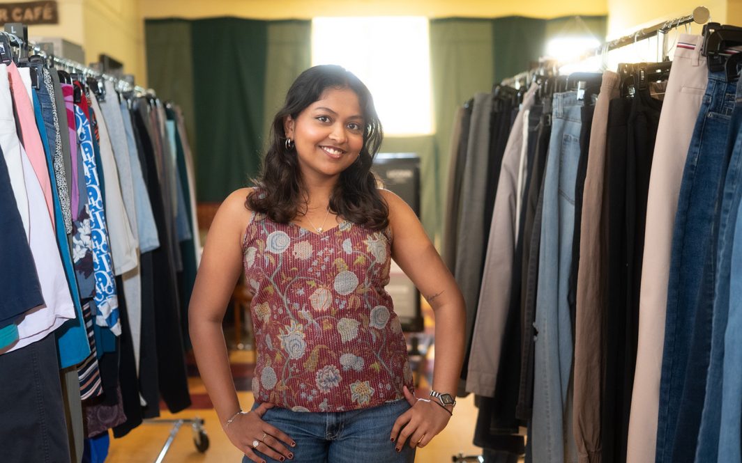 A UConn student stands in an aisle of clothing at the Thrift Den in Storrs, CT.
