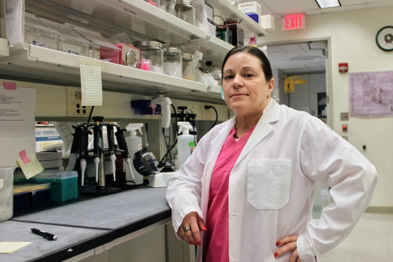 Woman standing in a laboratory in front of microscopes
